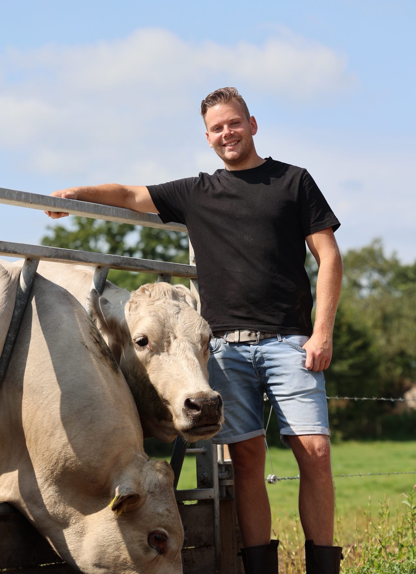 Foto van een broer naast twee koeien